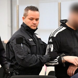 Ein Justizbeamter bringt einen Angeklagten in Handschellen in den Gerichtssaal, bevor der Prozess um einen Juwelenraub im Grünen Gewölbe des Dresdner Residenzschlosses fortgesetzt wird.