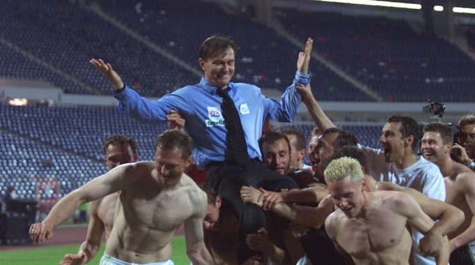 Die Spieler des 1. FC Köln heben ihren Trainer Ewald Lienen hoch.