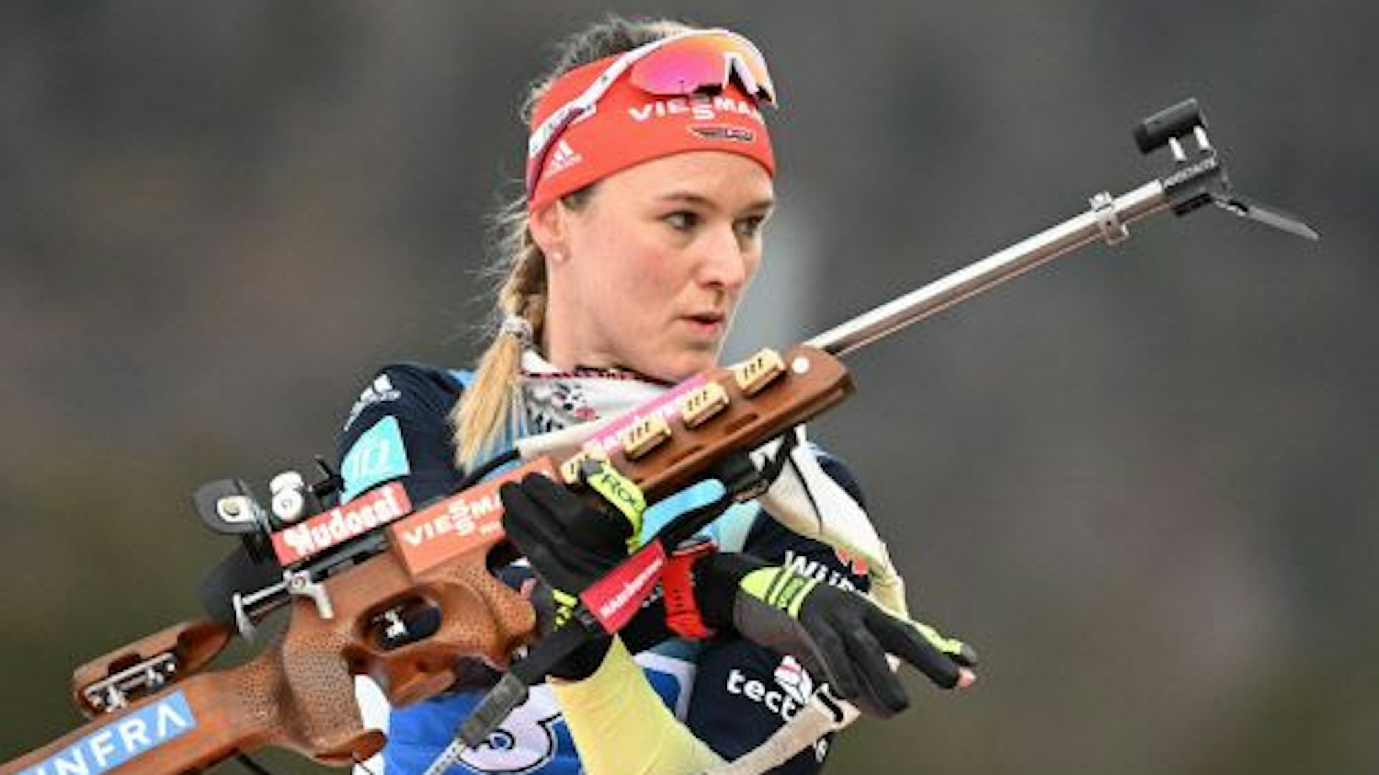 Biathletin Denise Herrmann-Wick steht mit einem Sportgewehr in der Hand am Schießstand in Ruhpolding.