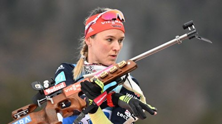 Biathletin Denise Herrmann-Wick steht mit einem Sportgewehr in der Hand am Schießstand in Ruhpolding.