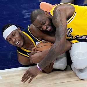 Myles Turner von den Indiana Pacers und LeBron James von den Los Angeles Lakers kämpfen am Boden liegend um den Ball.