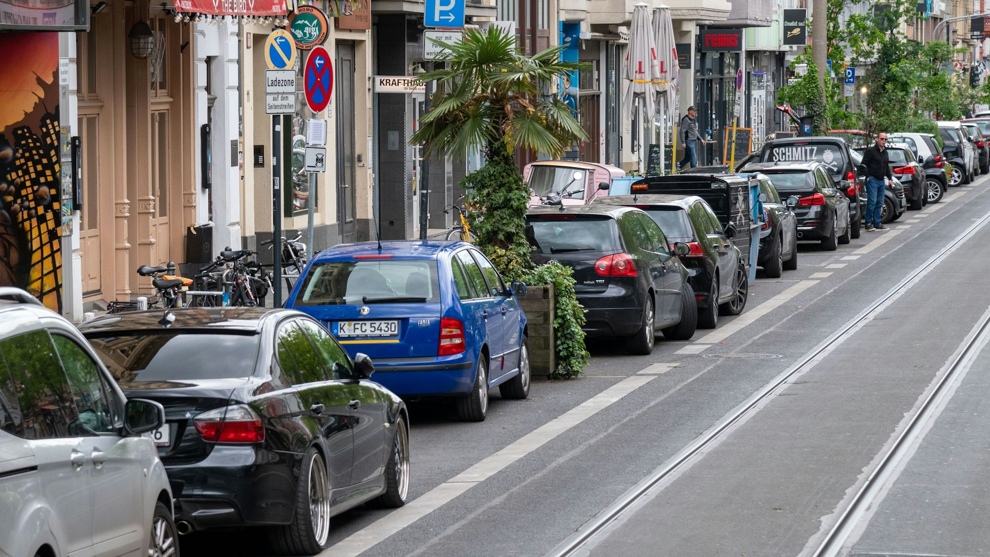 Aachener Straße in Köln mit geparkten Autos und Straßenbahnschienen