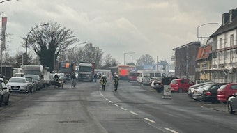 Mehrere Feuerwehrleute beim Einsatz auf der Straße.