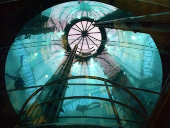 Das Foto aus dem Jahr 2003 zeigt den Berliner AquaDom, in dem sich zwei Tauchende befinden. Das riesige Aquarium innerhalb eines Hotels ist im Jahr 2022 zerbrochen.