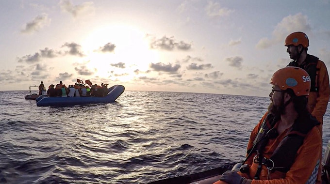 Die von der Seenotrettungsorganisation Sea-Eye herausgegebene Aufnahme zeigt Seenotretter vom Rettungsschiff «Alan Kurdi» die zu einem Schlauchboot voller Flüchtlinge schauen.&nbsp;