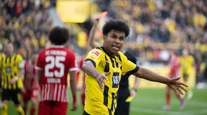 Dortmunds Karim Adeyemi jubelt, während Kiliann Sildillia (l) von Freiburg die Rote Karte sieht. 