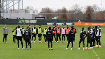 Das Team von Borussia Mönchengladbach steht bei einer Trainingseinheit am 2. Februar 2023 im Borussia-Park im Kreis zusammen. Co-Trainer Edmund Riemer gibt Anweisungen, einige Spieler tragen bunte Leibchen.