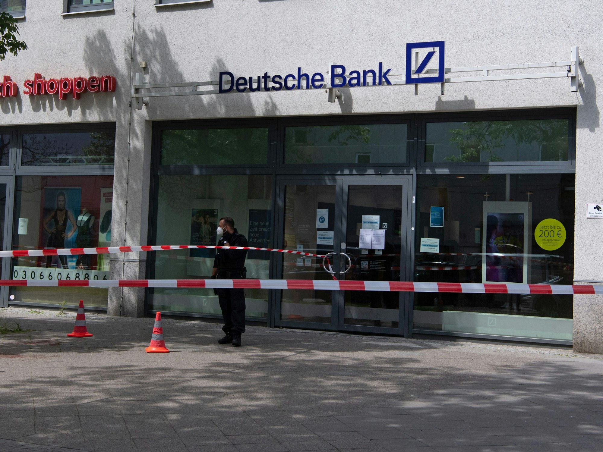 Ein Polizeibeamter steht vor einer Bankfiliale in den Gropius Passagen in Neukölln.