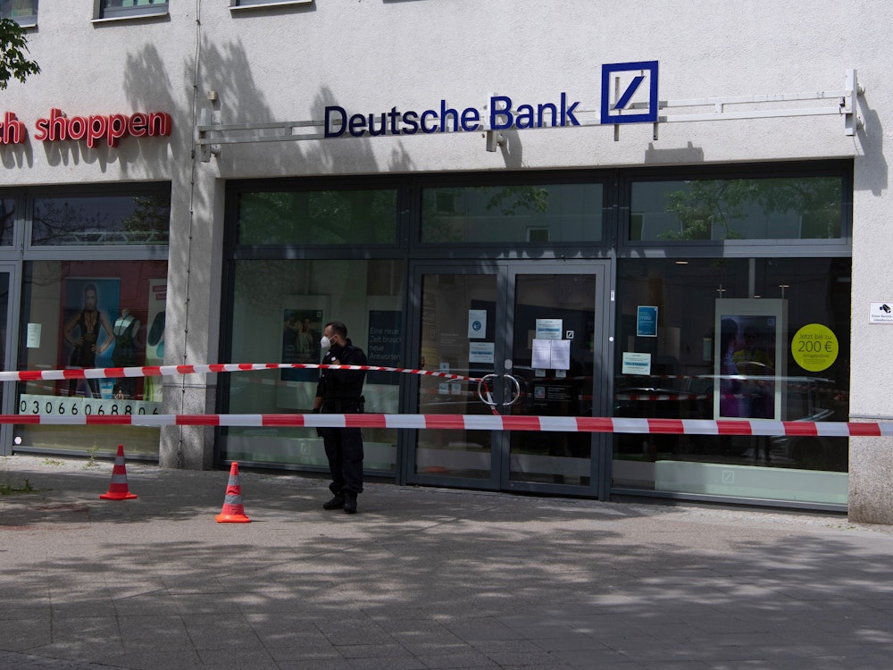 Ein Polizeibeamter steht vor einer Bankfiliale in den Gropius Passagen in Neukölln.