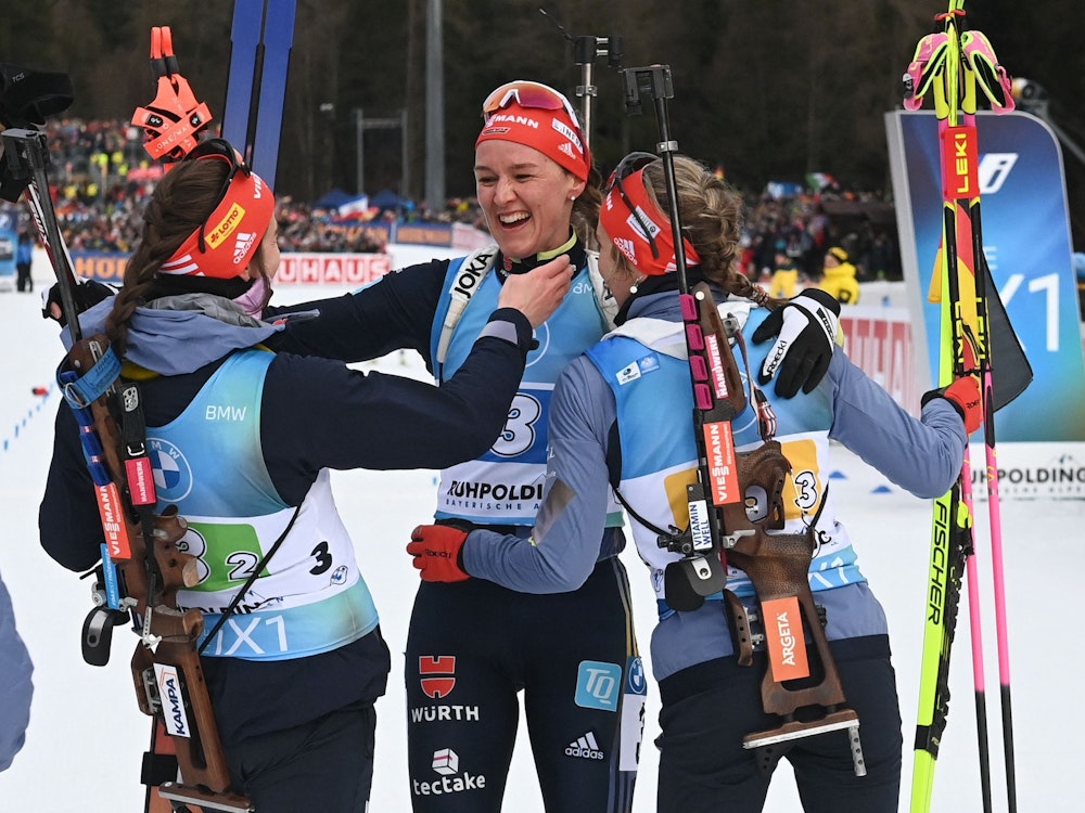 Denise Herrmann-Wick jubelt im Ziel gemeinsam mit Vanessa Voigt und Sophia Schneider, die nur von hinten zu sehen sind, über Platz zwei in der Staffel in Ruhpolding.