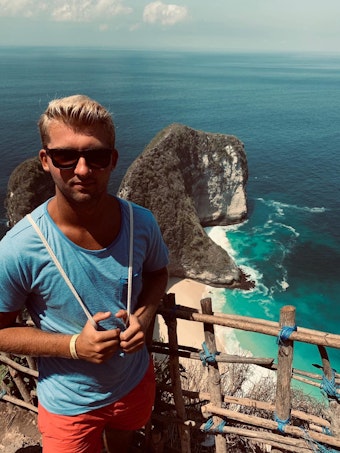 Nico Raddatz trägt bei einem Urlaub in Spanien vor der Kulisse des Mittelmeers eine Sonnenbrille.