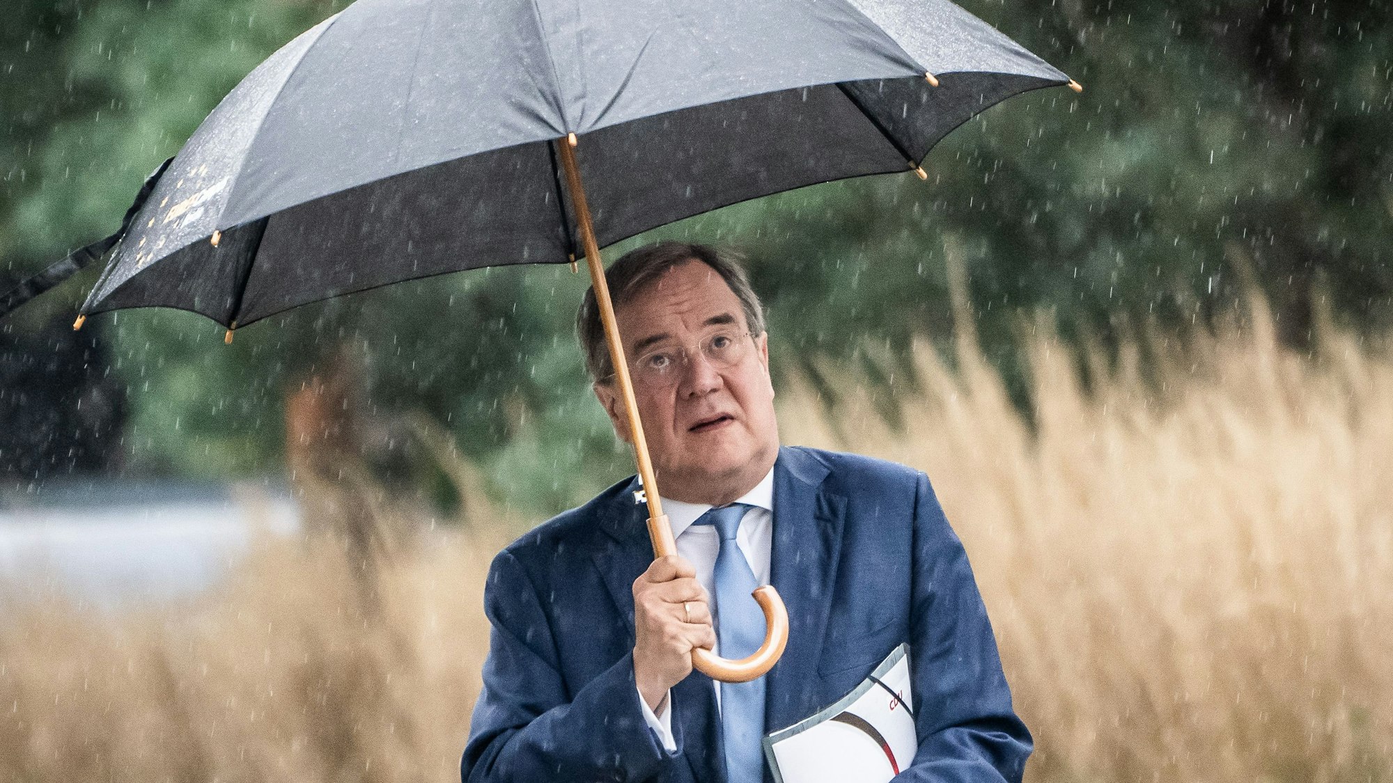 Armin Laschet, CDU-Bundesvorsitzender und Ministerpräsident von Nordrhein-Westfalen, kommt unterm Regenschirm zu Sondierungsgesprächen zwischen der CDU und Bündnis 90/Die Grünen nach der Bundestagswahl. +++ dpa-Bildfunk +++