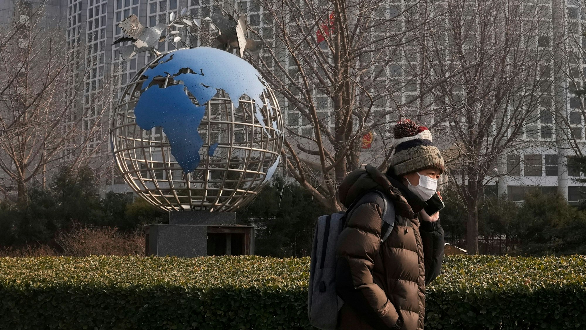 China, Peking: Eine Frau geht an einer Globusskulptur vorbei, die vor dem Büro des chinesischen Außenministeriums in Peking steht. (Symbolbild)