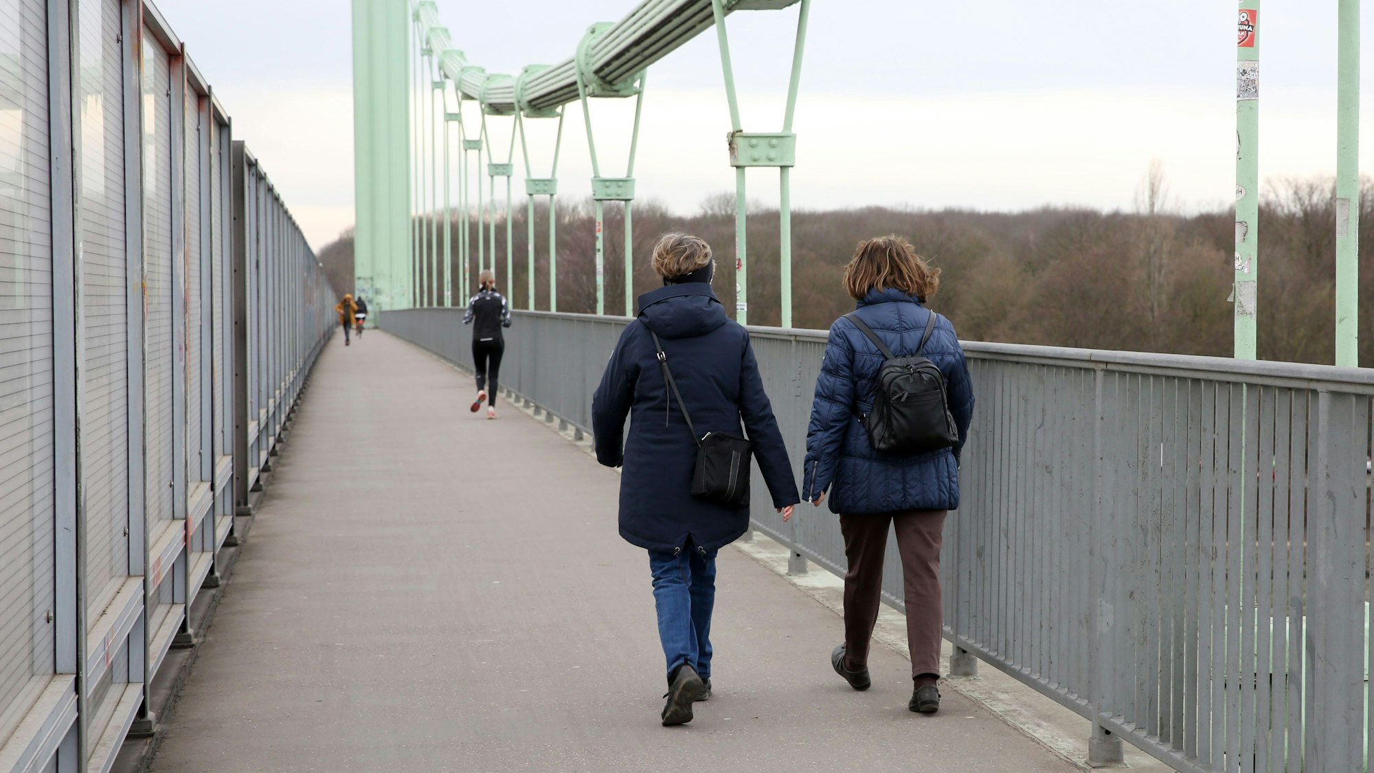 zwei Frauen laufen über eine Brücke