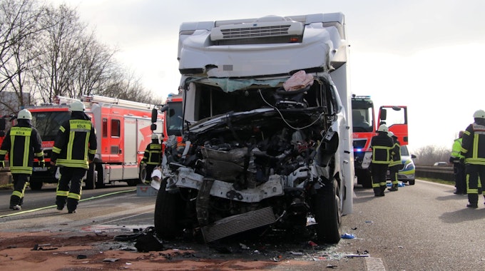 Ein Kleintransporter steht mit völlig beschädigter Fahrerkabine auf der A59. Einsatzkräfte der Feuerwehr wuseln herum.