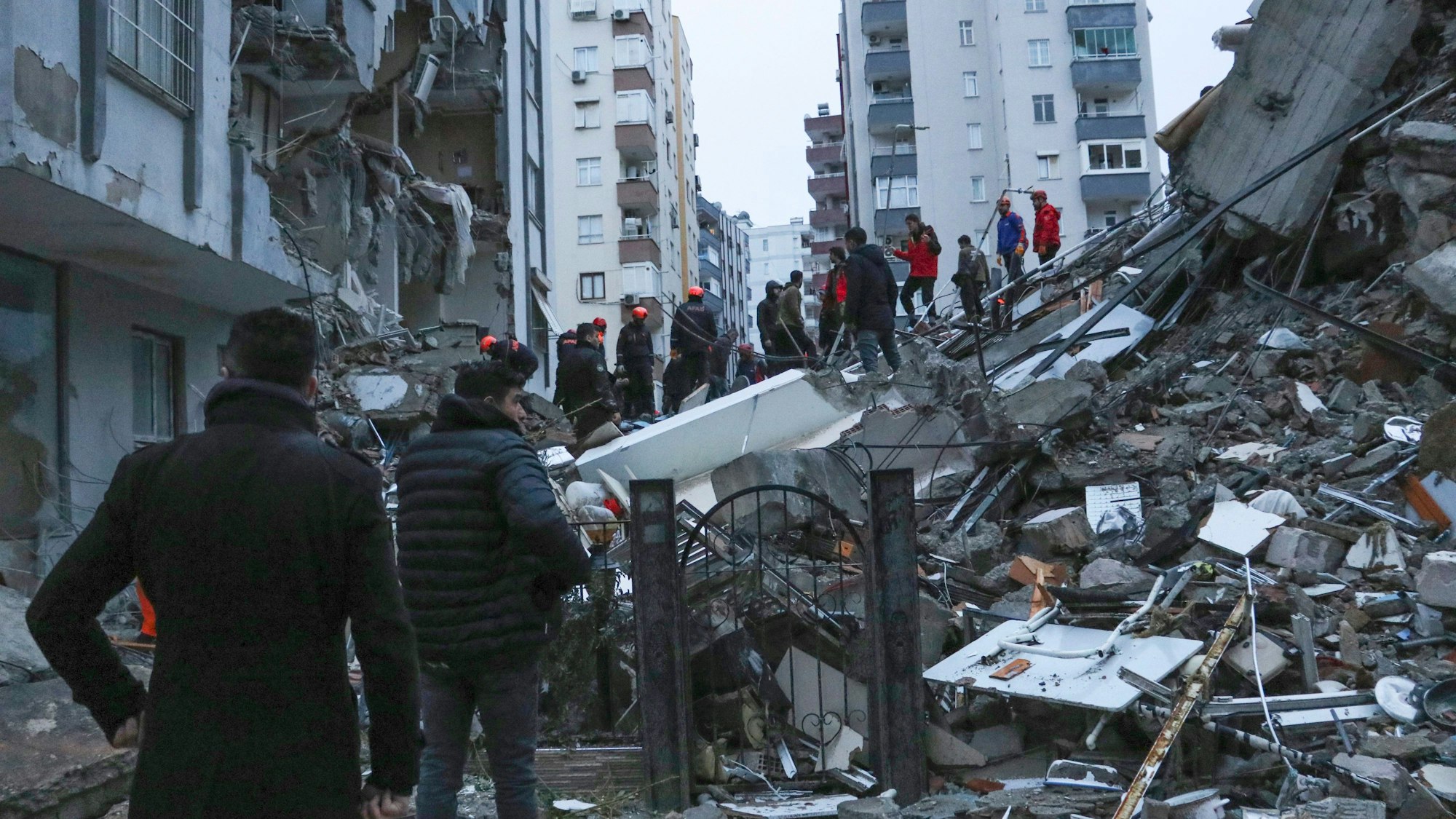 Türkei, Adana: Menschen und Rettungsteams versuchen, eingeschlossene Bewohner in eingestürzten Gebäuden zu erreichen.