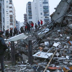 Türkei, Adana: Menschen und Rettungsteams versuchen, eingeschlossene Bewohner in eingestürzten Gebäuden zu erreichen.