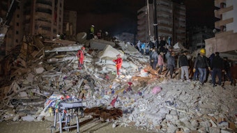 Türkei, Adana: Rettungskräfte suchen nach Überlebenden in den Trümmern von Gebäuden.