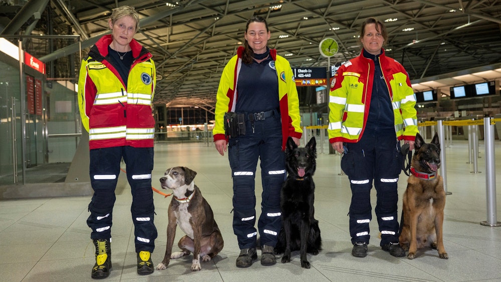 Frau Boysen, Frau Lambert und Frau Pilger mit ihren Personensuchhunden. Rettungskräfte mit Suchhunden checken am Flughafen ein um Erdbebenopfer in der Türkei zu helfen.