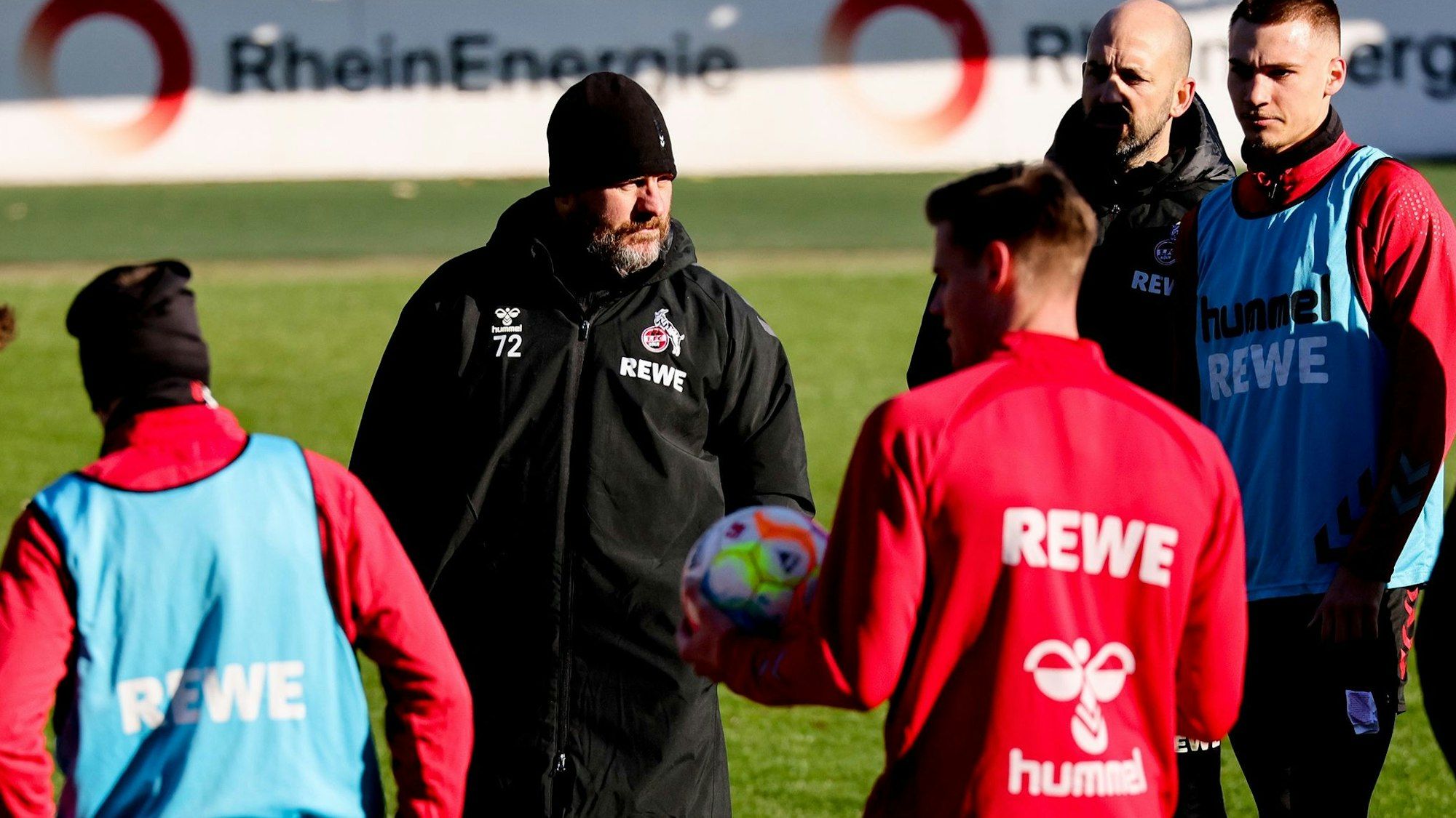 Steffen Baumgart spricht mit seinen Spielern auf dem Trainingsplatz, der Trainer des 1. FC Köln trägt am eisigen Dienstagmorgen (7. Februar) eine wärmende Mütze.