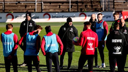 Steffen Baumgart spricht mit seinen Spielern auf dem Trainingsplatz, der Trainer des 1. FC Köln trägt am eisigen Dienstagmorgen (7. Februar) eine wärmende Mütze.&nbsp;