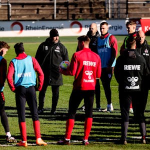 Steffen Baumgart spricht mit seinen Spielern auf dem Trainingsplatz, der Trainer des 1. FC Köln trägt am eisigen Dienstagmorgen (7. Februar) eine wärmende Mütze.&nbsp;