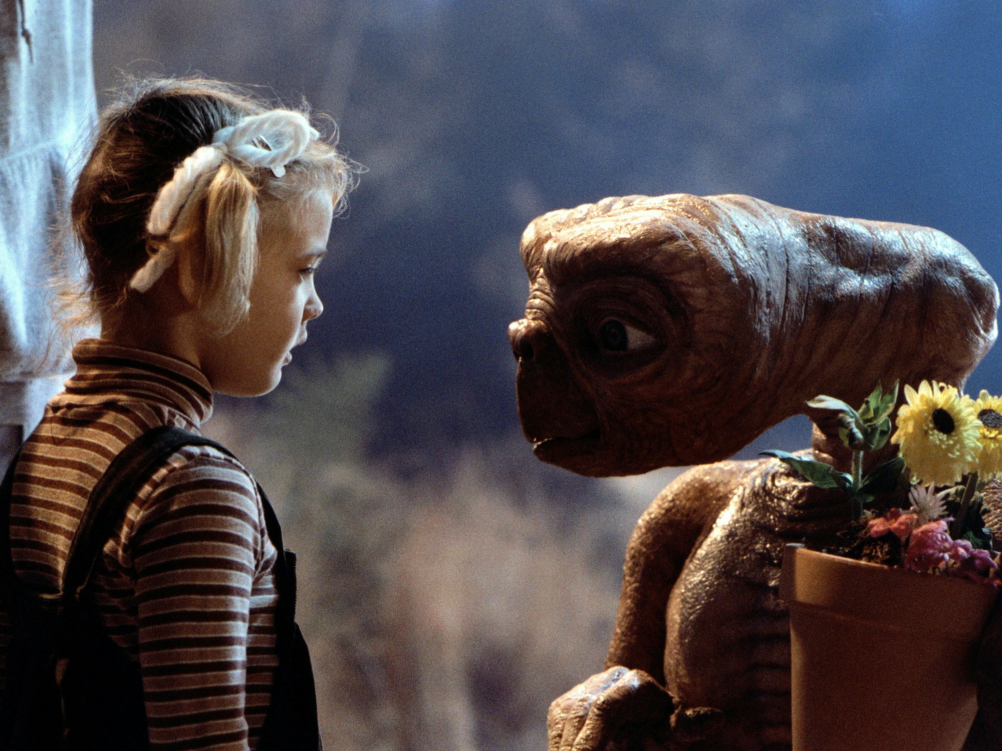 Der Außerirdische E.T. und Kinderdarstellerin Drew Barrymore als „Gertie“ schauen sich in die Augen.