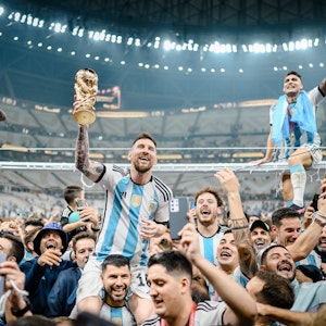 Lionel Messi (M) aus Argentinien wird nach seinem Triumph im WM-Finale von Sergio Agüero auf die Schultern genommen, um den argentinischen Fans den WM-Pokal zu präsentieren.