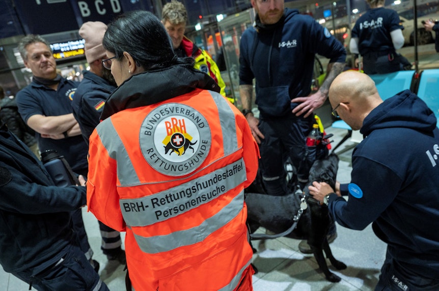 Rettungskräfte mit Suchhunden checken am Flughafen ein, um Erdbebenopfern in der Türkei zu helfen.