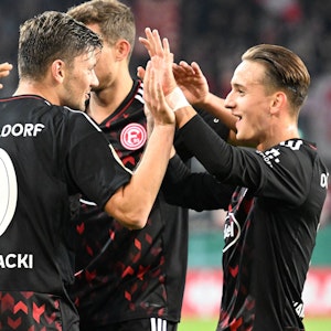 Die Spieler von Fortuna Düsseldorf klatschen sich im DFB-Pokalspiel bei Jahn Regensburg nach einem Treffer ab.