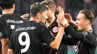 Die Spieler von Fortuna Düsseldorf klatschen sich im DFB-Pokalspiel bei Jahn Regensburg nach einem Treffer ab.