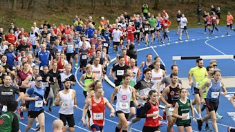 Zahlreiche Läuferinnen und Läufer sprinten auf einer blauen Tartanbahn.