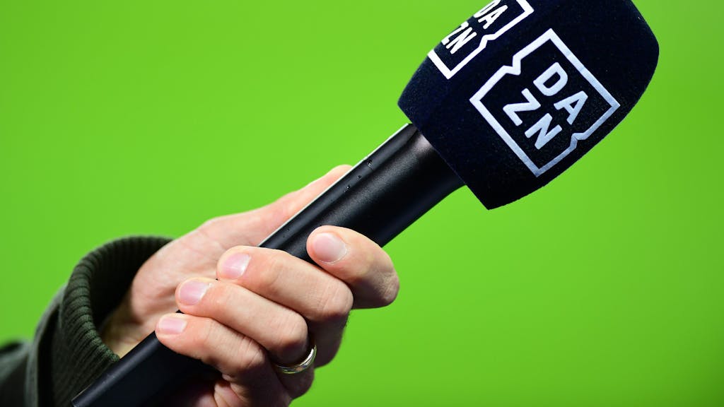 Die Hand eines Reporters hält bei einem Interview vor dem Spiel ein Mikrofon mit der Aufschrift DAZN.&nbsp;