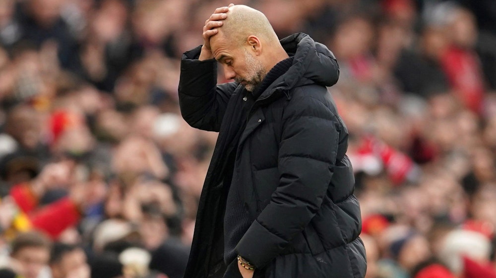 Trainer Pep Guardiola Manchester City fasst sich an den Kopf. Gegen seinen Klub wird ermittelt wegen möglicher Verstöße gegen Transferregeln.