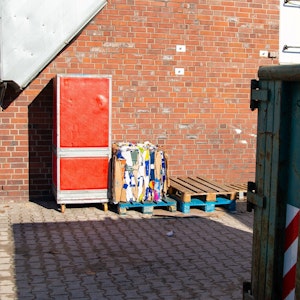 Ein Kühlcontainer steht draußen an einer Wand.