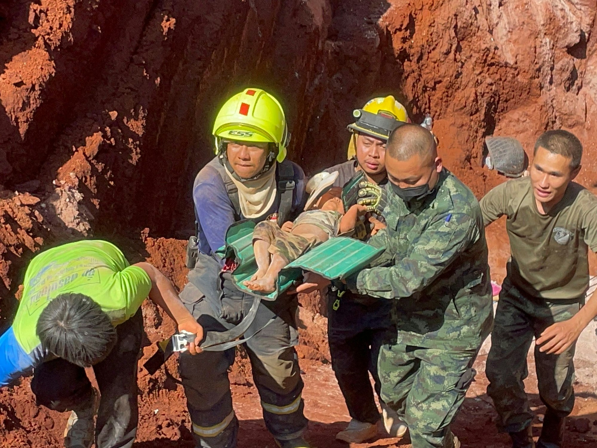 Nach einer nächtlichen Rettungsaktion tragen Rettungskräfte und Militärs ein einjähriges Kind aus einem tiefen Loch in der nordthailändischen Provinz Tak, 420 km nördlich von Bangkok.