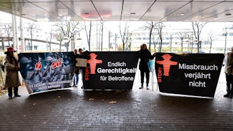 Unterstützer von Kläger Georg Menne stehen vor dem Landgericht Köln und halten Plakate mit der Aufschrift: "Missbrauch verjährt nicht" und "Endlich Gerechtigkeit für Betroffene" hoch. Der 62-Jährige verklagt das Kölner Erzbistum auf mehr als 700 000 Euro Schmerzensgeld - weil er Opfer sexueller Gewalt durch einen katholischen Priester geworden sei. +++ dpa-Bildfunk +++