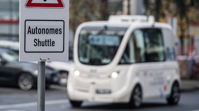 Ein Schild „Autonomes Shuttle“ weist auf dem Flughafen in Frankfurt am Main (Hessen) auf den Testbetrieb hin. Der Flughafenbetreiber Fraport testet selbstfahrende Shuttles auf dem Flughafen-Betriebsgelände.