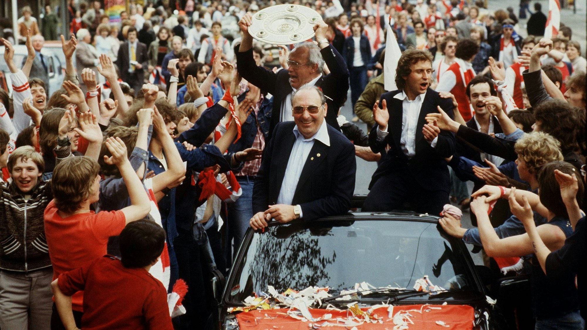 Hennes Weisweiler (mit Meisterschale) lässt sich im FC-Tross nach der gewonnenen Meisterschaft 1978 von jubelnden Menschen in Köln feiern.