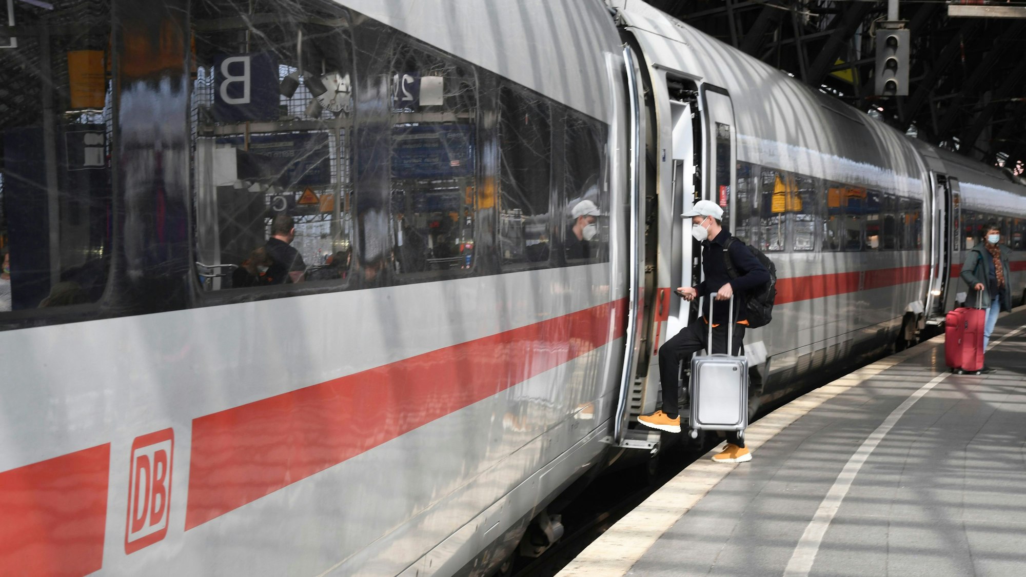 Ein Reisender steigt an Bahnsteig im Hauptbahnhof Köln in seinen Zug.