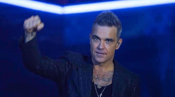 Robbie Williams ballt eine Faust auf der Bühne.