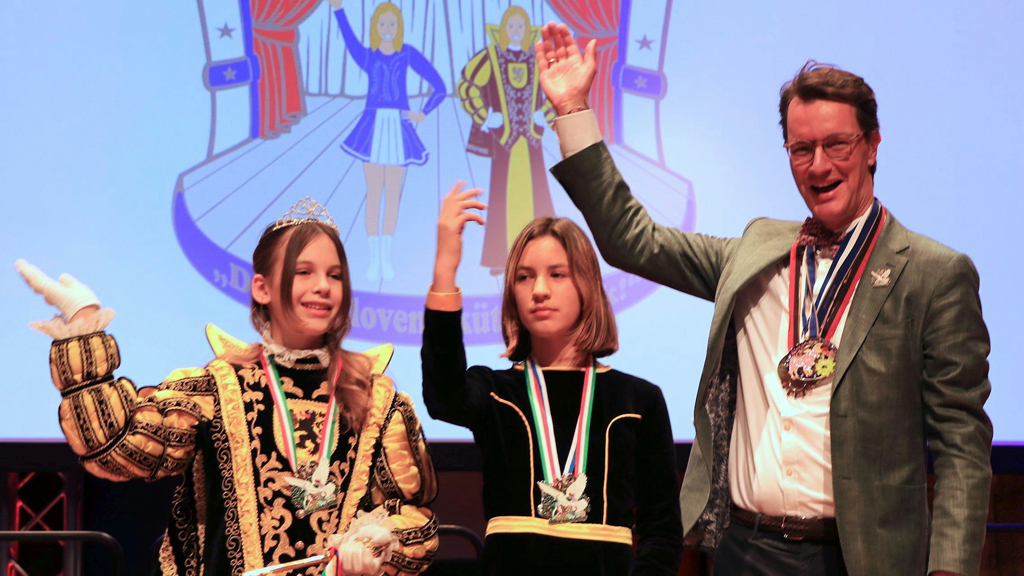 Das Bild zeigt die Frechener Kinderprinzessin Gerta I. mit Pagin Malina und den NRW-Ministerpräsidenten Hendrik Wüst.