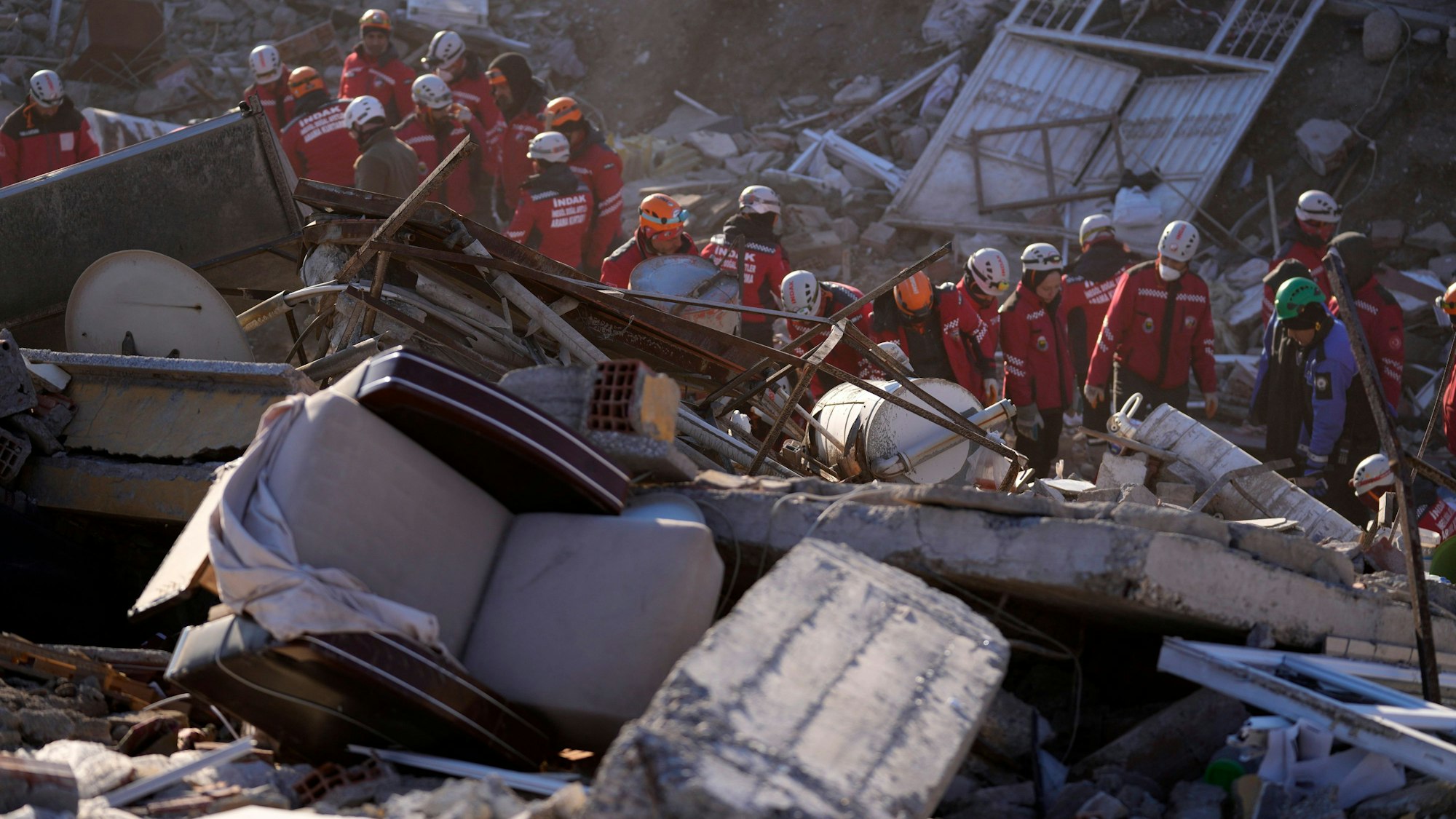 Türkei, Kahramanmaras: Rettungskräfte durchsuchen die Trümmer eines zerstörten Gebäudes nach Überlebenden.
