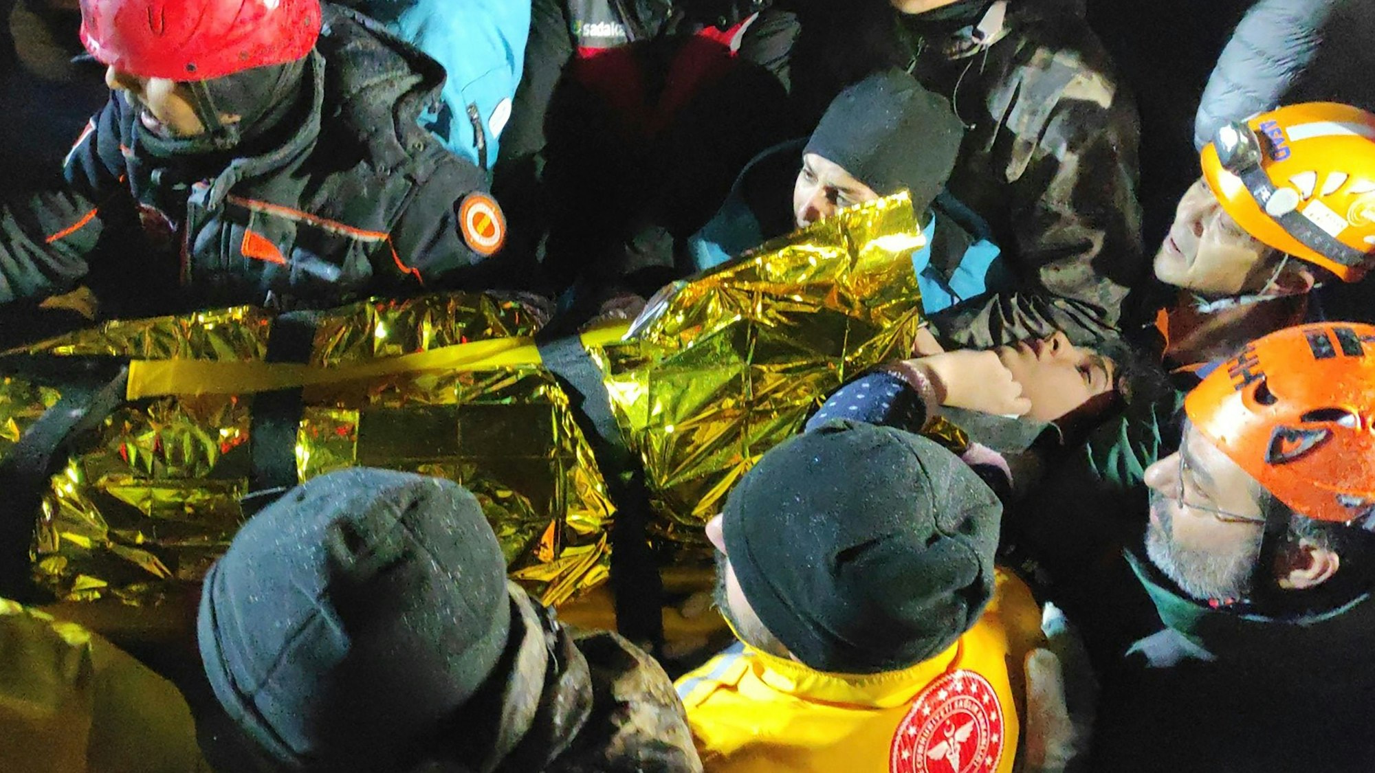 Rettungskräfte und Sanitäter tragen eine junge Frau, die sie aus den Trümmern eines eingestürzten Gebäudes in Sanliurfa in der Südtürkei gerettet haben.