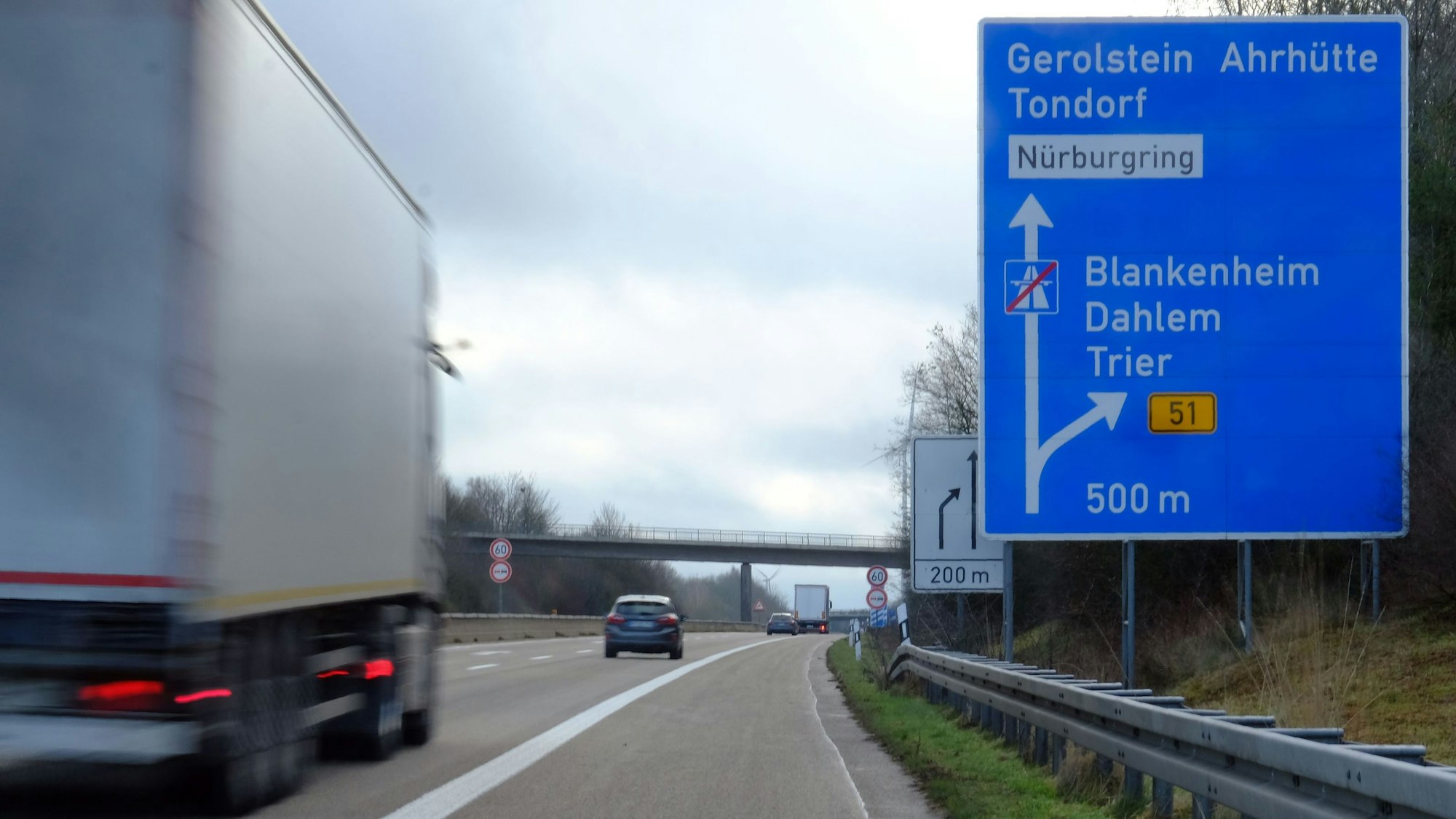 Ein Lastwagen fährt am Autobahnende der A1 bei Blankenheim an einem Hinweisschild vorbei.
