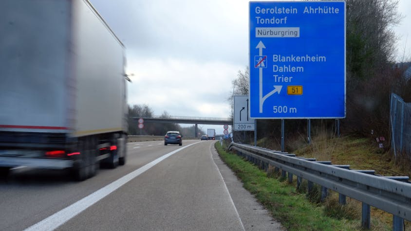 Ein Lastwagen fährt am Autobahnende der A1 bei Blankenheim an einem Hinweisschild vorbei.