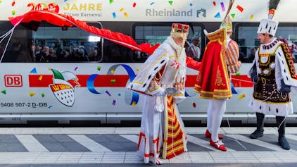 Das Kölner Dreigestirn vor einem karnevalistisch dekorierten ICE