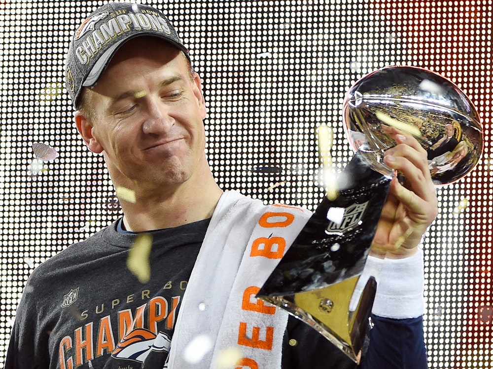 Peyton Manning schaut sich die Vince Lombardi Trophy in seiner Hand an.