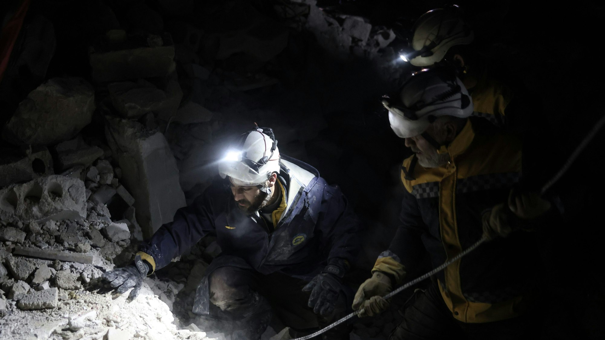 Mitglieder der Weißhelme arbeiten an der Rettung von Menschen, die nach dem verheerenden Erdbeben an der türkisch-syrischen Grenze, unter einem zerstörten Gebäude eingeschlossen sind. Einer Frau haben die Helfer nun das Leben gerettet.