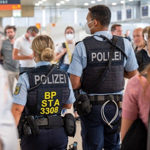 Eine Beamtin und ein Beamter der Bundespolizei gehen durch den Flughafen Köln/Bonn.